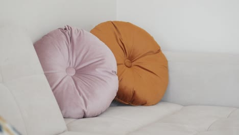 round velvet pillows on a white sofa