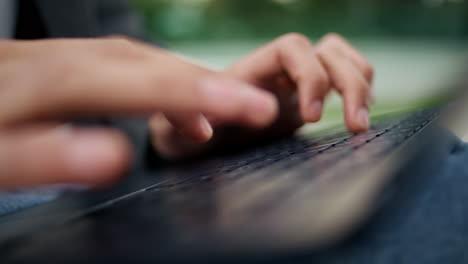 hombre manos escribiendo teclado en la ciudad de primer plano. estudiante desconocido usando macro portátil