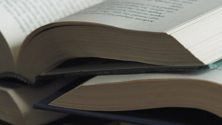Pila di libri aperti, ripresa slider in macro primo piano con movimento da sinistra a destra.