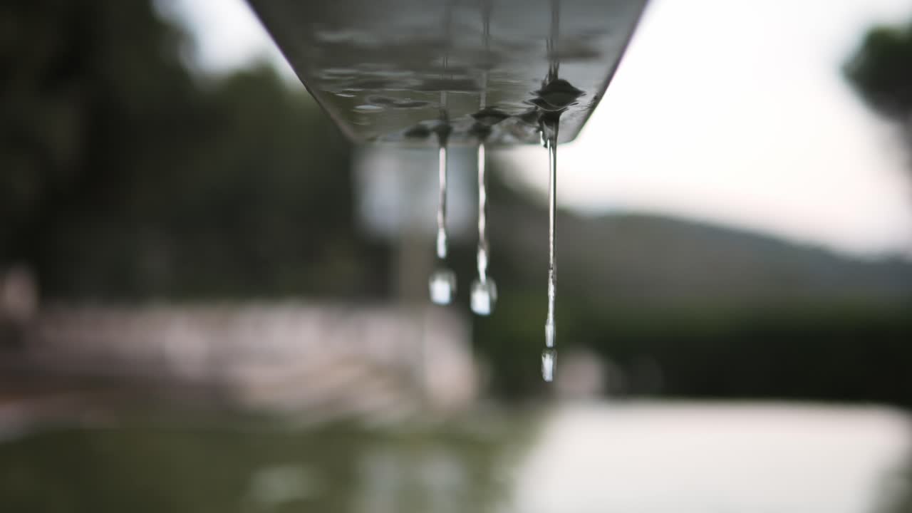 Rain Drops Dripping from Metal Gutter