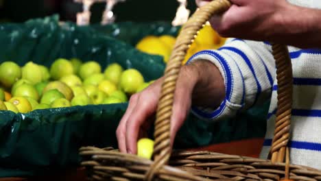 man with a basket selecting fruit in organic section