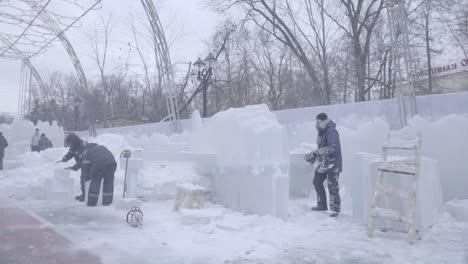 ice sculptures being constructed in a winter park