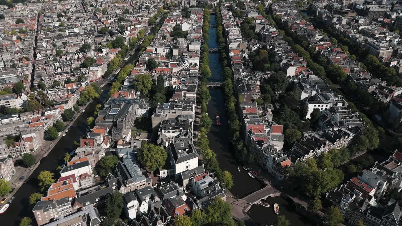 Aerial circle reveals four canals weaving through green summer Amsterdam
