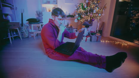 hombre trabajando en una computadora portátil en casa durante la navidad