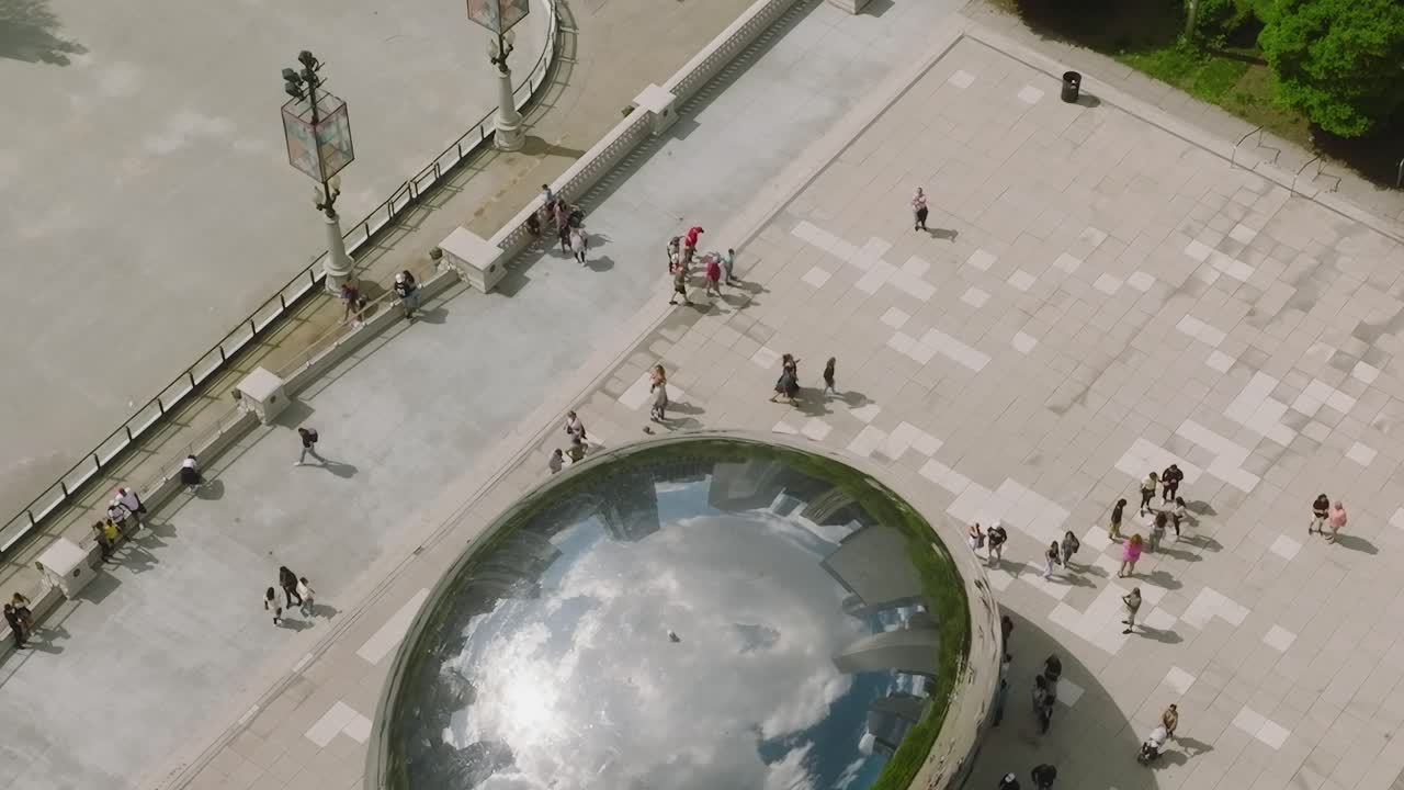 View of park with large reflective sculpture and people in Chicago