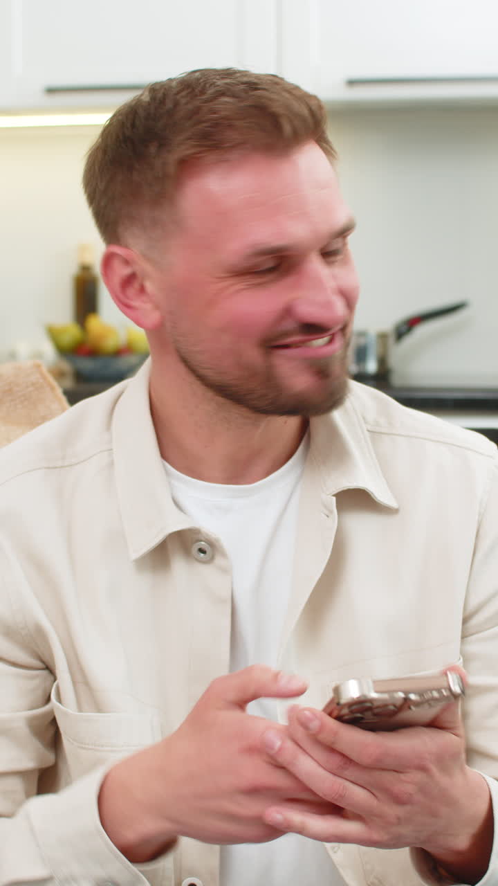 Young man cheers celebrating app win laughing with smartphone joyful reaction excited shout success