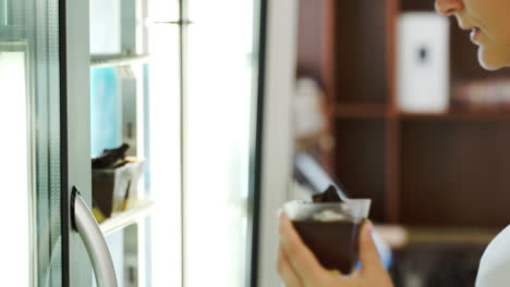 mujer tomando pastel del refrigerador en la tienda