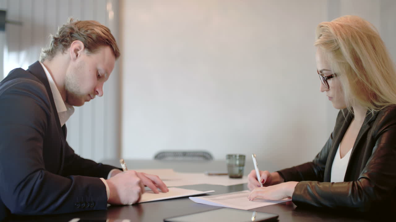 Donna d'affari che firma documenti con un cliente in ufficio