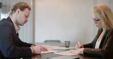 businesswoman signing documents with client in the office