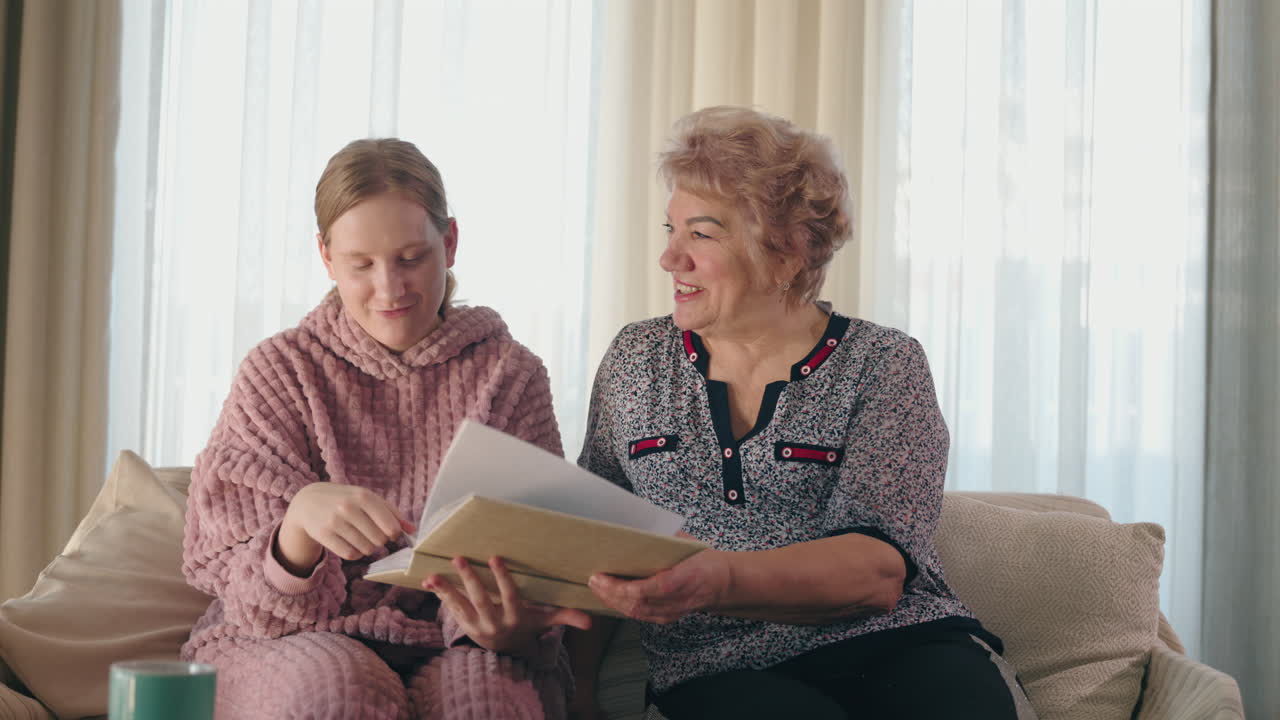 할머니 와 손녀 가 사진 앨범 을 보고 있다