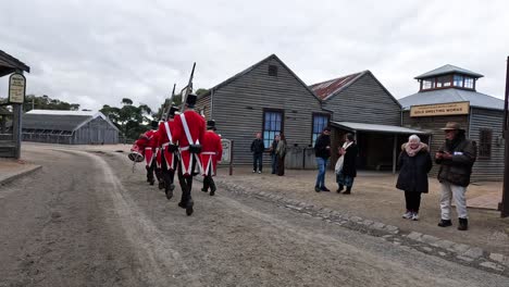 soldiers in red uniforms marching through historic town