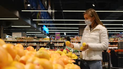 a woman in a supermarket picks fresh oranges in rubber gloves a woman in a supermarket picks fresh oranges in rubber gloves healthy eating to boost your immune system citrus fruits in the supermarket