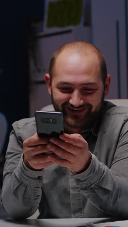 vertical video entrepreneur man smiling at phone while writing financial strategy planner