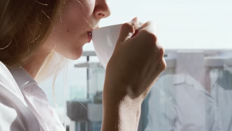 vista de cerca de una mujer caucásica bebiendo café en un hotel