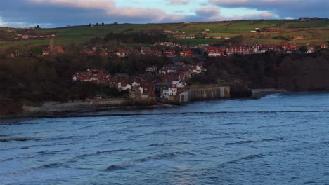 establishing wide angle shot of robin hood's bay at sunrise yorkshire