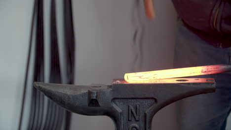 blacksmith hammering red hot metal on an anvil