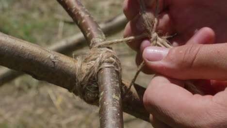 bushcrafter finishing cross bond on a wooden construction