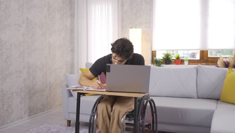 estudiante discapacitado trabajando con una computadora portátil en casa.