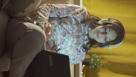 video vertical de un estudiante masculino escuchando música y estudiando por la noche.