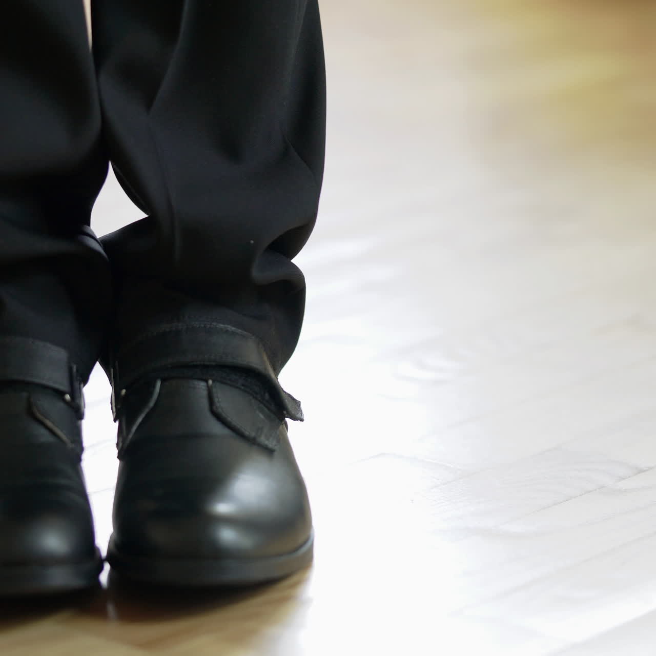 Young man comes to the room and goes back - detail of legs in shoes inside. Walking feet of a businessman on the wooden floor. Close-up