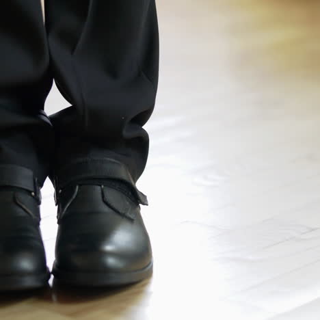 young man comes to the room and goes back - detail of legs in shoes inside. walking feet of a businessman on the wooden floor. close-up