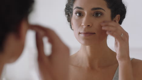 retrato de una hermosa mujer joven mirándose en el espejo con una piel perfecta y saludable tocando la cara con las manos disfrutando de una tez natural suave con cuidado de la piel antienvejecimiento preparándose en casa concepto de belleza