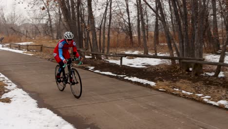 racing cyclist rides past on a cold snowy day