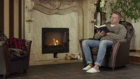 man reading by the fireplace