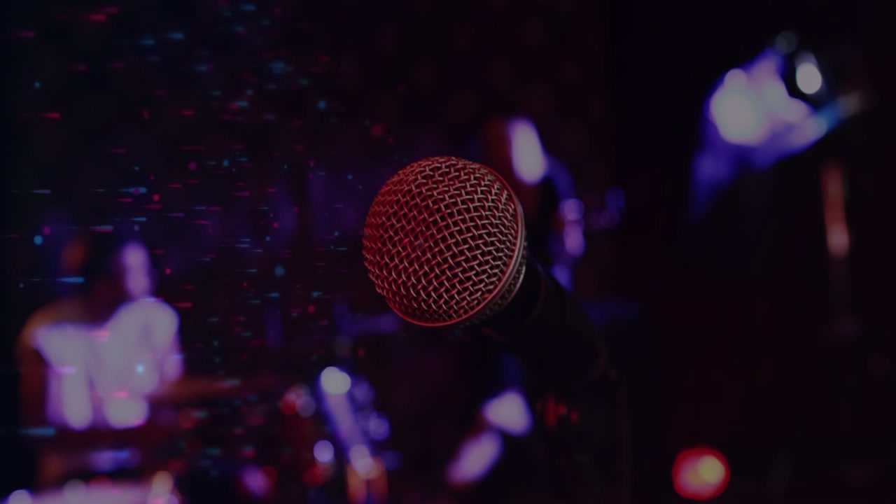 Handheld mic framing as drummer starting beat pulsing lights haze across band adding music mood
