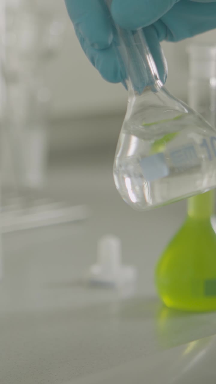 Scientist handling flask with green liquid in a lab setting