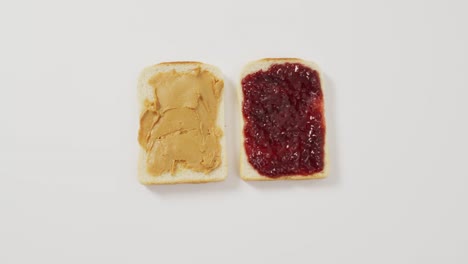 close up view of peanut butter and jelly sandwich with copy space on white surface