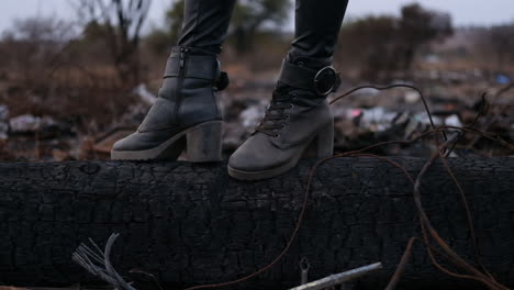 girl with leather boots standing in dumpsite