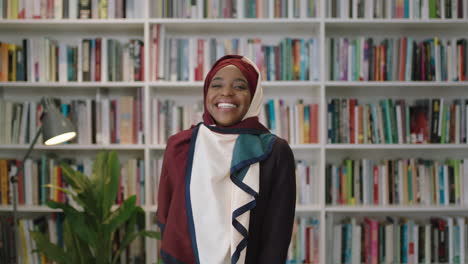 portrait of young lovely african american woman laughing looking at camera student standing in library