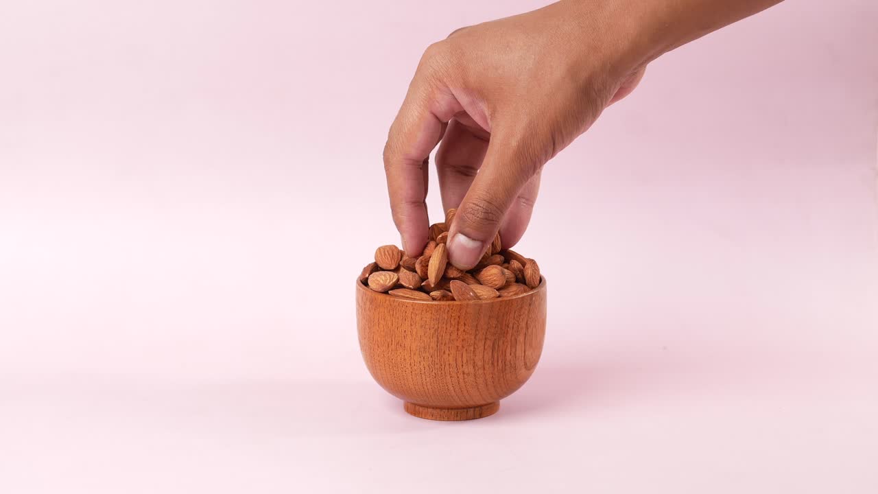 Hånd som plukker mandler, sett fra siden
