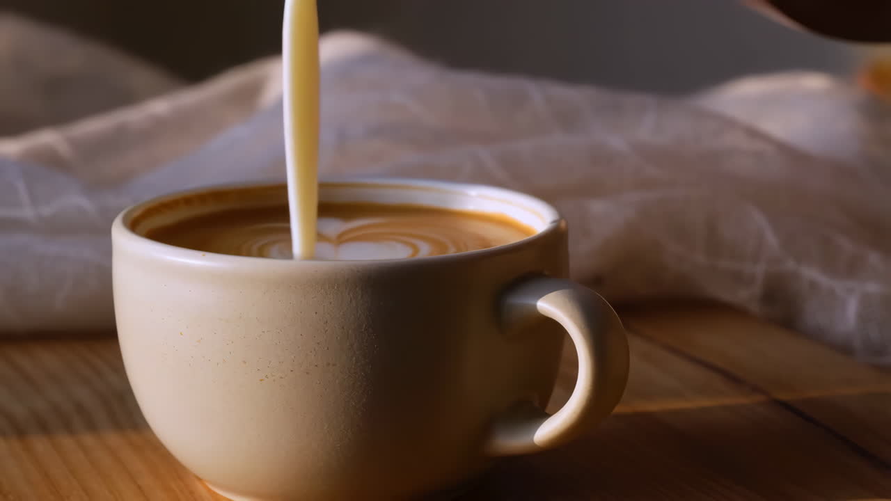 Pouring milk into a coffee cup to create latte art