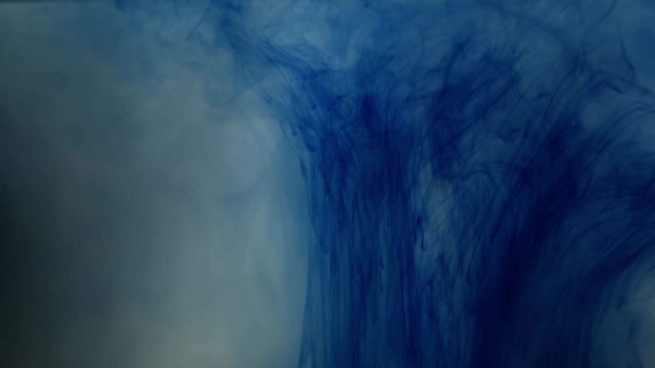 Illusione di fumo creata da inchiostro blu in una vasca d'acqua trasparente, in slow motion.