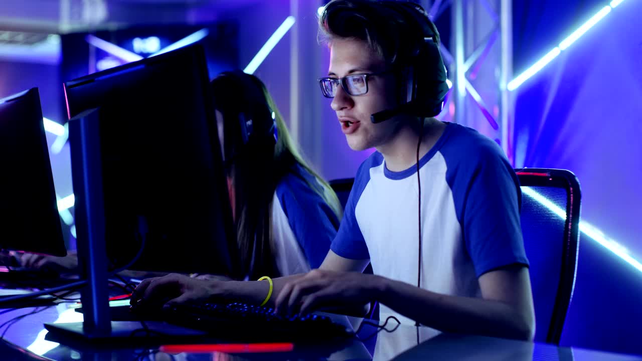 Team of Teenage Gamers Play in Multiplayer  Video Game on a eSport Tournament. Captain Gives Commands into Microphone, Trying Strategically Win the Game.