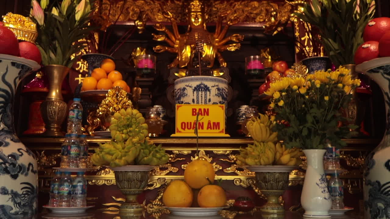 Ornate altar decorated with fruit, flowers, and incense offerings in a traditional Vietnamese temple