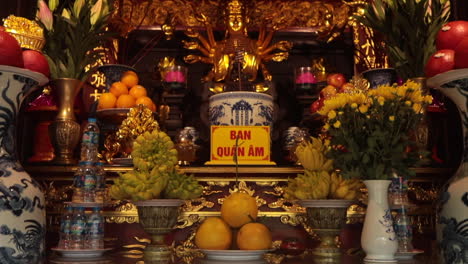 ornate altar decorated with fruit, flowers, and incense offerings in a traditional vietnamese temple