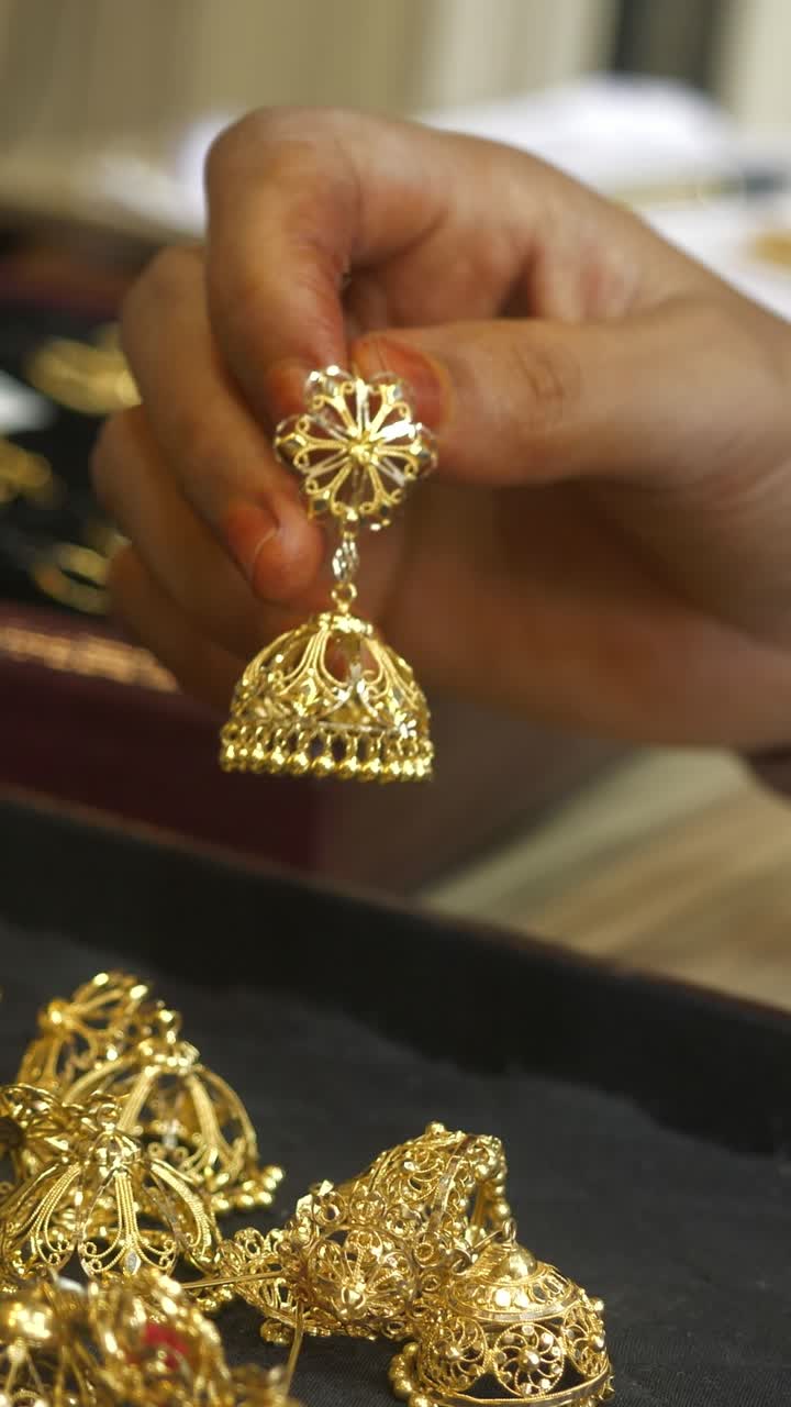 Female customer shopping for 22k hallmarked gold jewellery at a shop, Gold investment, vertical shot