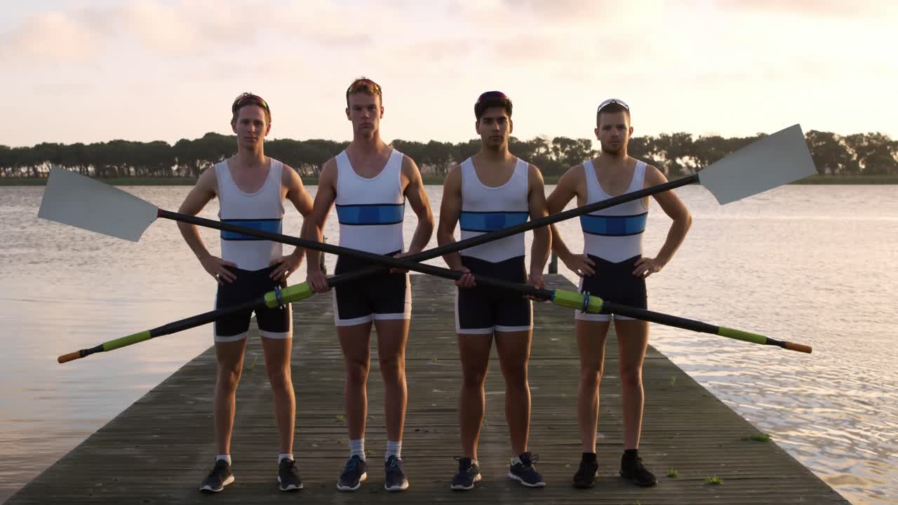 Rower male team looking at camera with oars in their hands