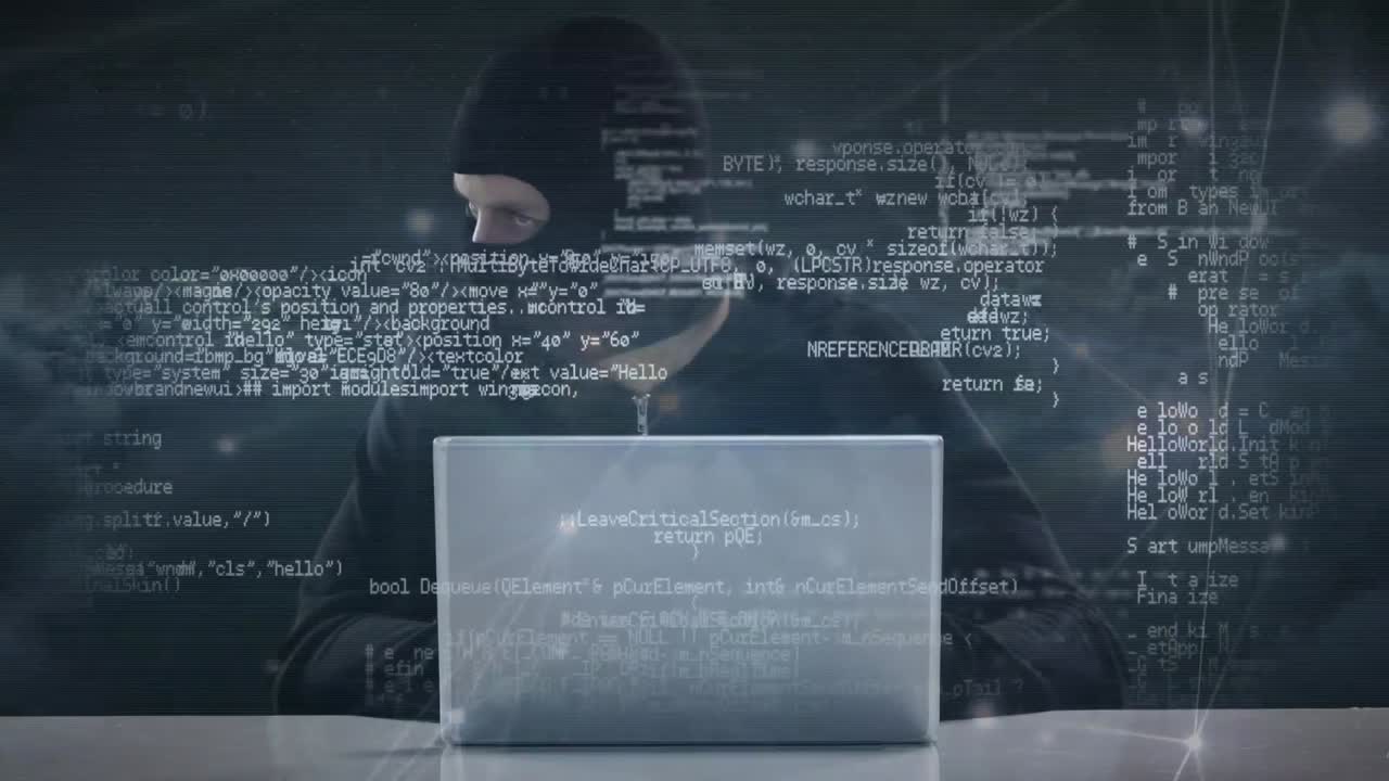 Hacker in ski mask typing on laptop while looking around nervously