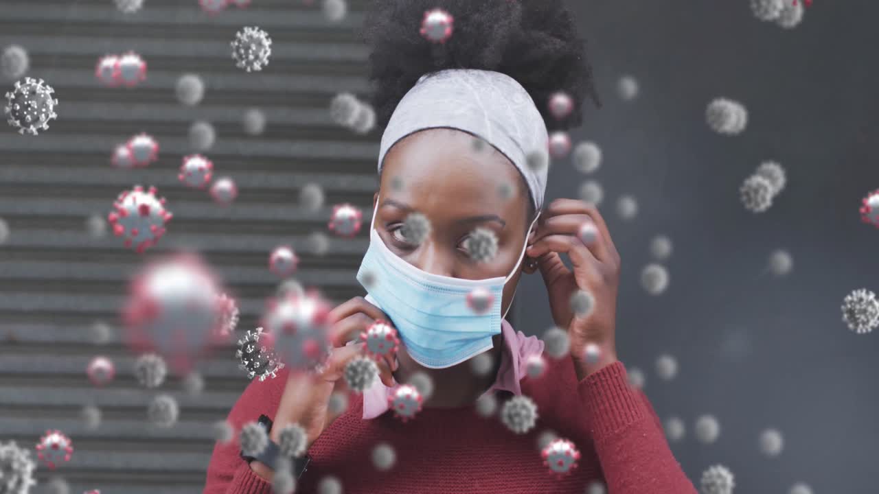Animation of covid 19 cells over african american woman wearing face mask