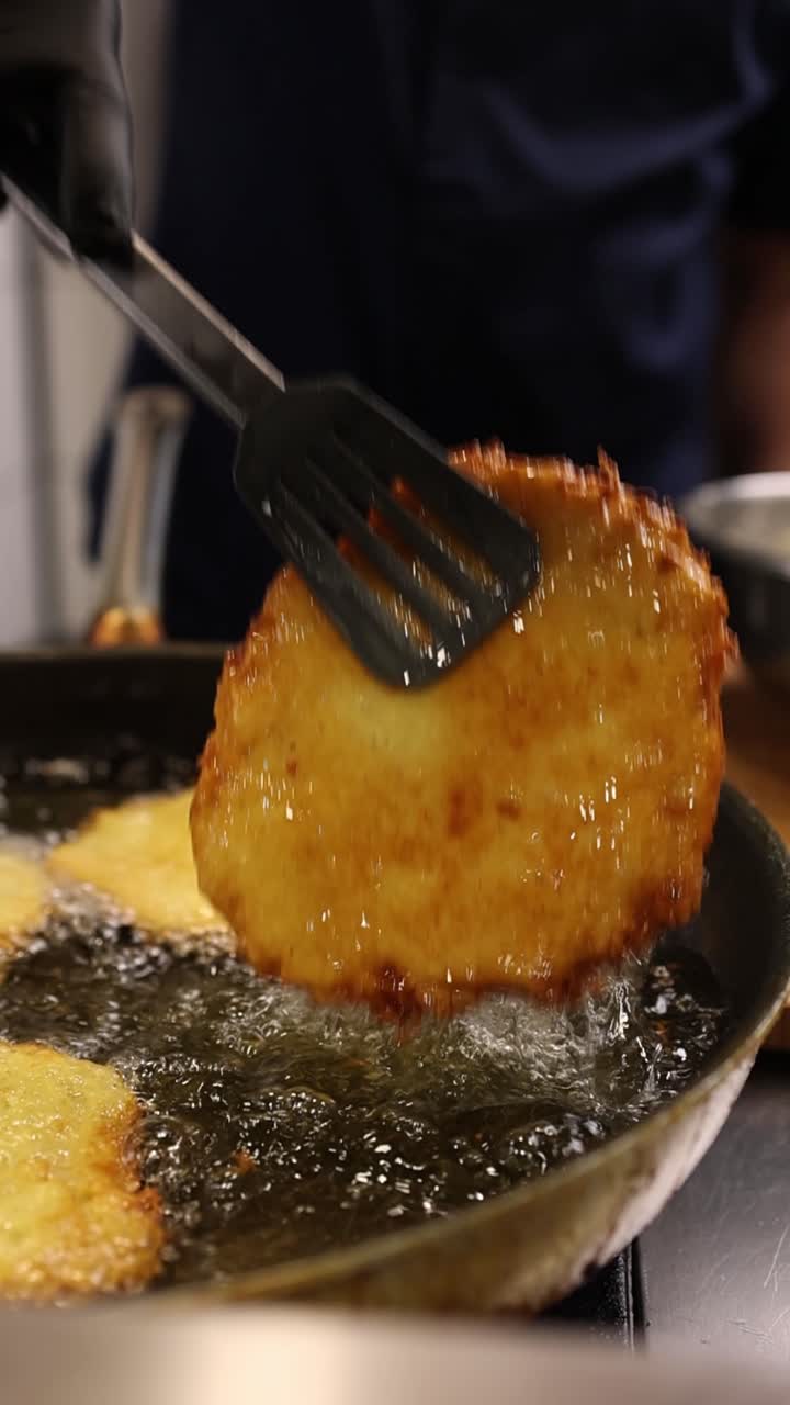 Chef che frigge un pancake di patate dorato in olio bollente