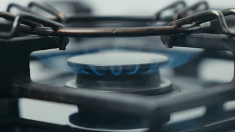 close-up of a gas stove burner with a blue flame