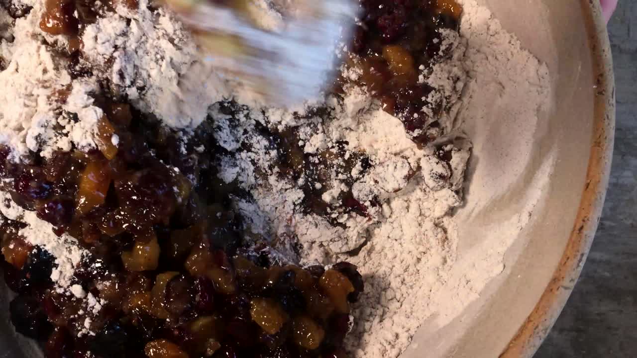 큰 그릇 윗면에서 나무 숟가락으로 과일 케이크 재료를 혼합