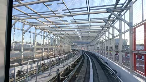 a train navigates through a modern urban setting in tokyo, showcasing dynamic movement and architectural structures under clear daylight