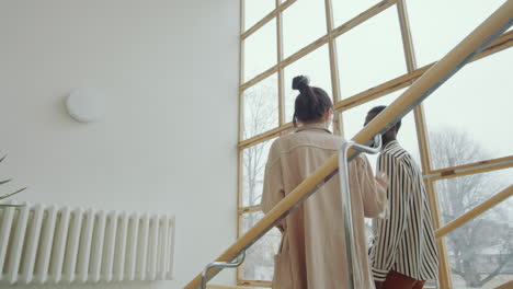 Multiethnic-Man-and-Woman-Walking-Downstairs-and-Speaking