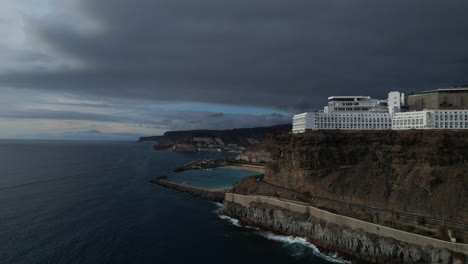 fantastic aerial shot in orbit and revealing the beach of amadores and the big hotels in the area, during sunset on the island of gran canaria