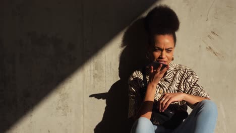 mixed race woman talking on smartphone under bridge